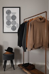 Photo of Modern dressing room interior with stylish clothes, shoes and decorative elements