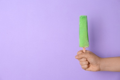 Woman holding delicious ice cream against color background, space for text