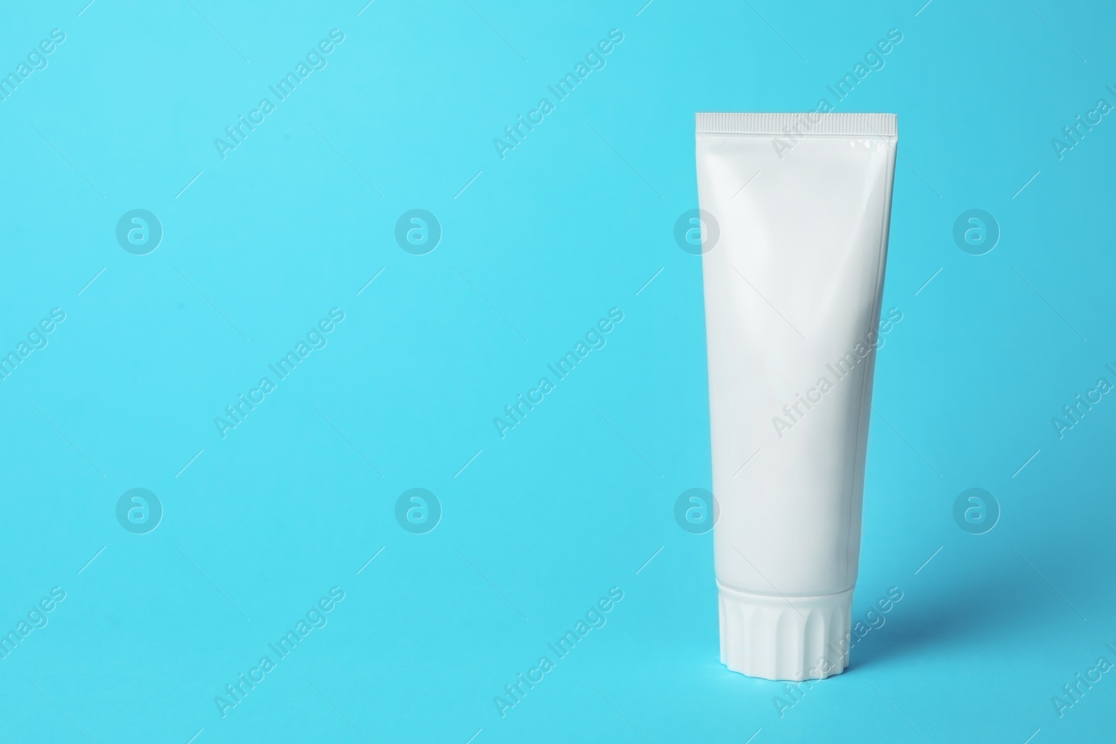 Photo of Blank tube of toothpaste on color background. Space for text