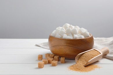 Photo of Different types of sugar on white wooden table, space for text