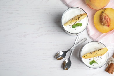 Tasty peach dessert with yogurt and chia seeds served on white wooden table, flat lay. Space for text