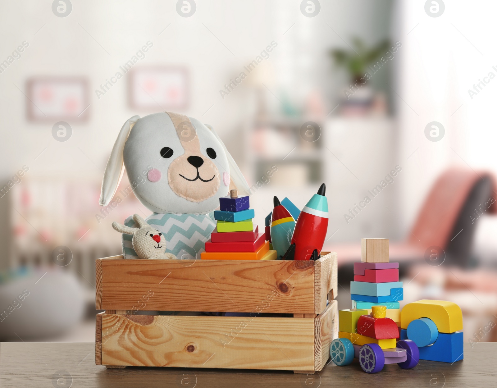 Image of Set of different cute toys on wooden table in children's room