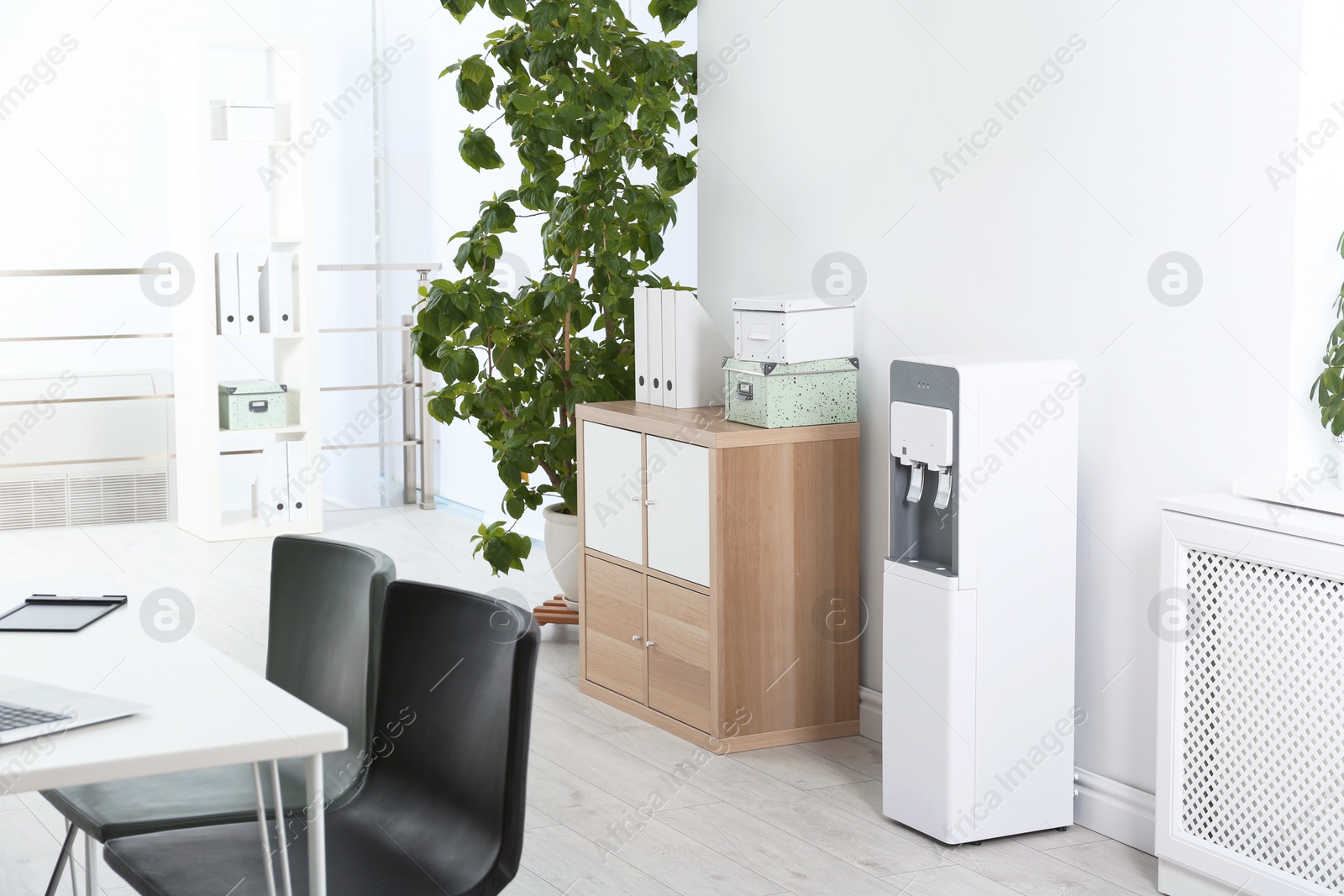 Photo of Modern water cooler in stylish office interior