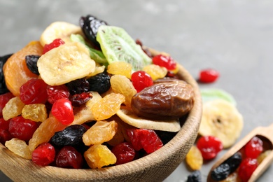 Photo of Bowl with different dried fruits on grey background, space for text. Healthy lifestyle