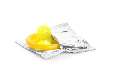 Photo of Unpacked yellow condom isolated on white. Safe sex