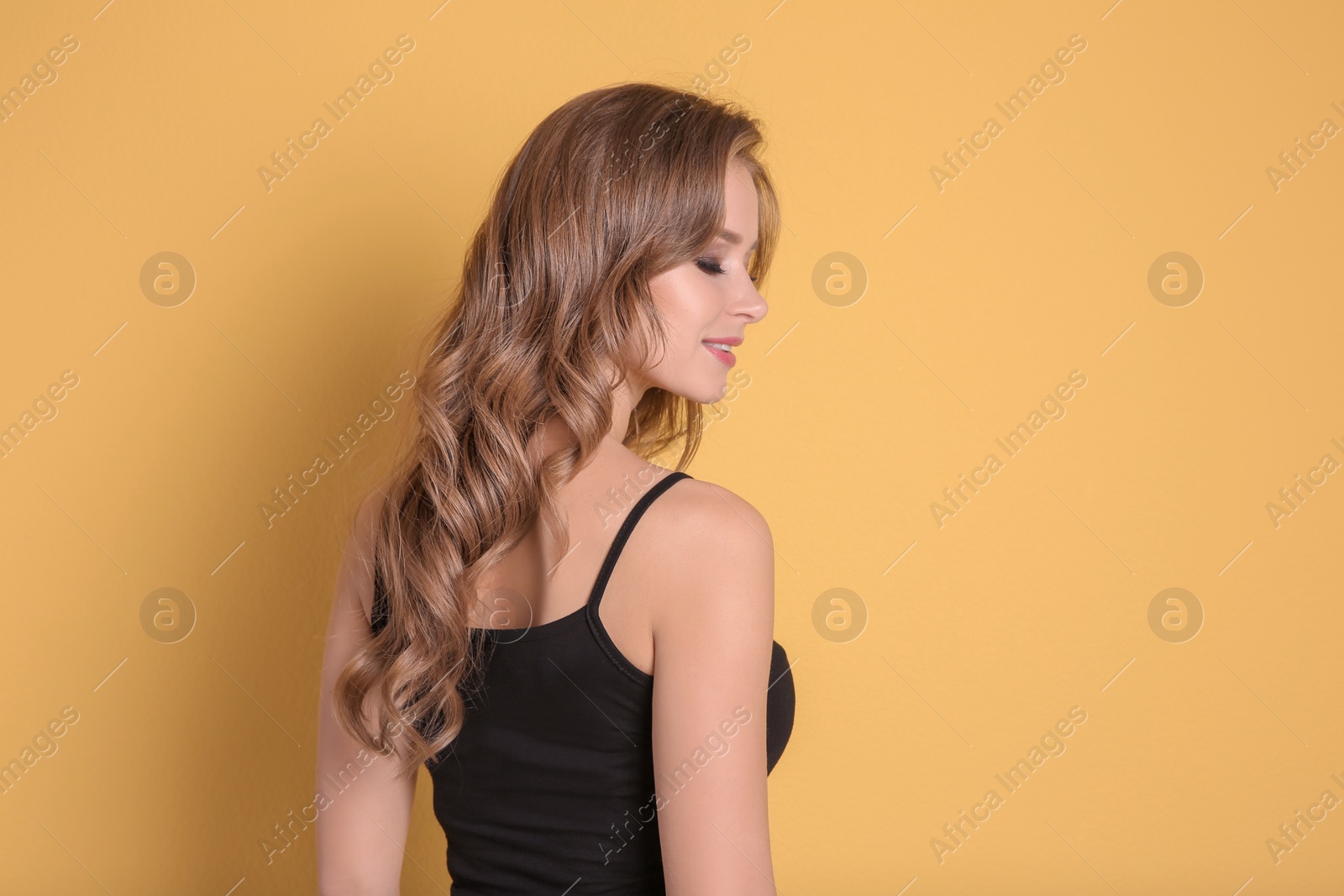 Photo of Portrait of young woman with long beautiful hair on color background