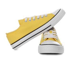 Pair of yellow classic old school sneakers on white background