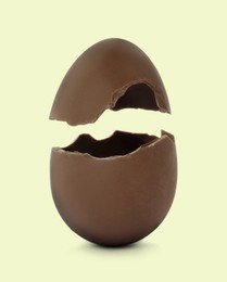Image of Broken milk chocolate egg on light background