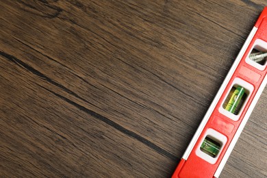 Photo of Building level on wooden table, top view. Space for text