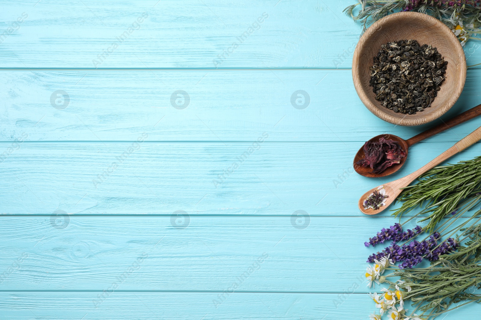 Photo of Flat lay composition with healing herbs on light blue wooden table. Space for text