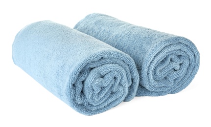 Photo of Rolled clean blue towels on white background