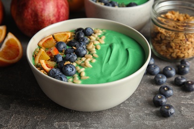 Photo of Composition with bowl of spirulina smoothie on table