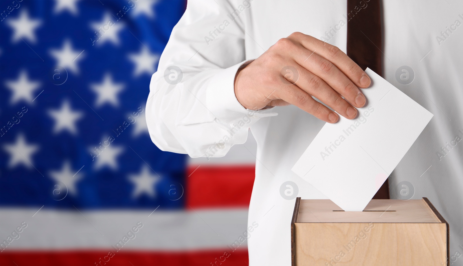 Image of Election in USA. Man putting his vote into ballot box against national flag of United States, closeup. Banner design