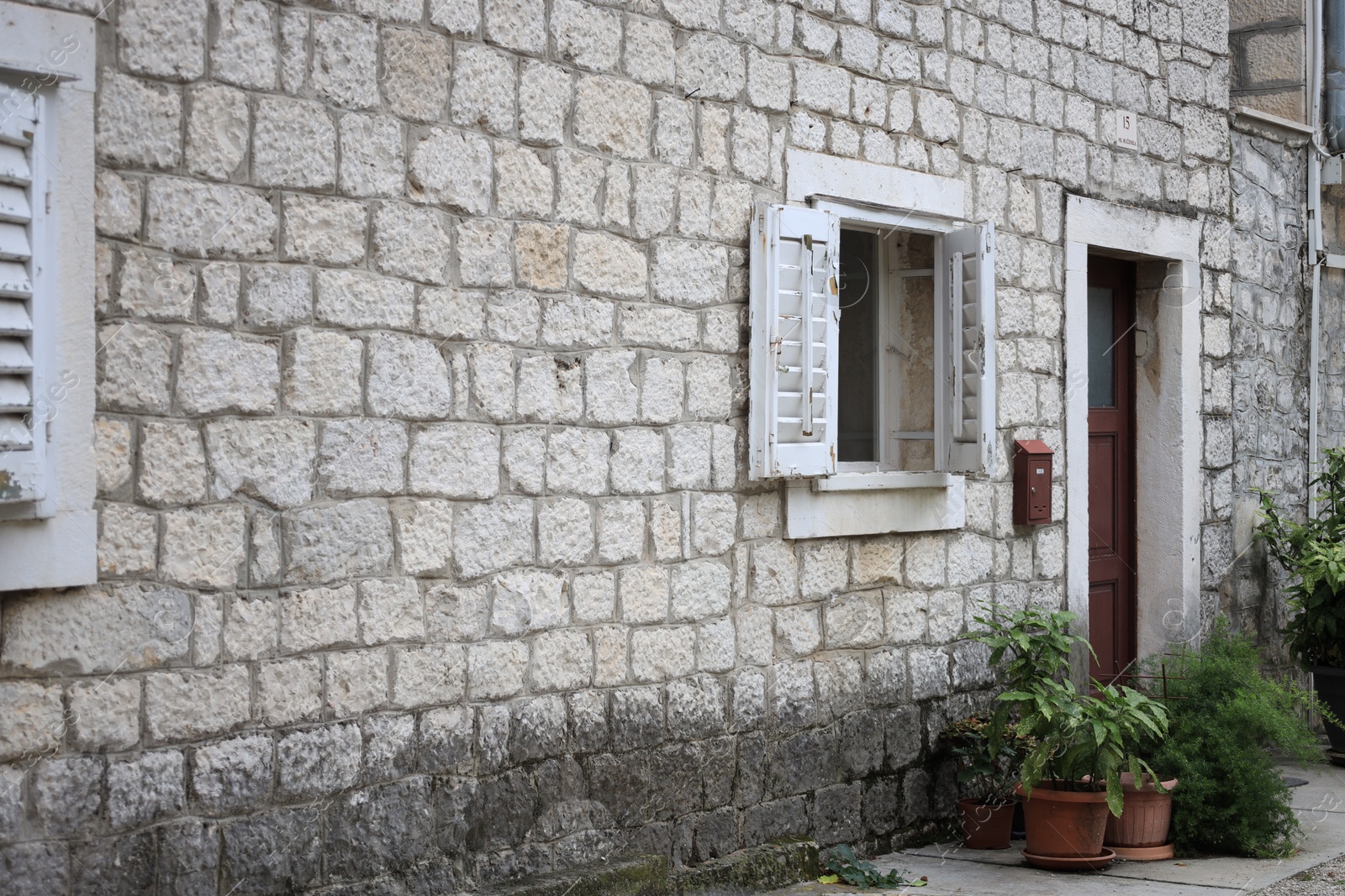 Photo of Beautiful old building with stone wall, window and door
