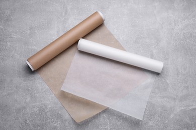 Photo of Rolls of baking paper on light grey table, flat lay