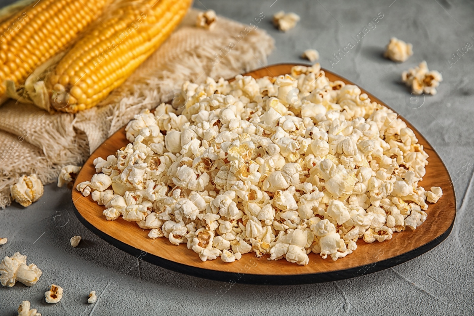 Photo of Plate with delicious popcorn on table, closeup