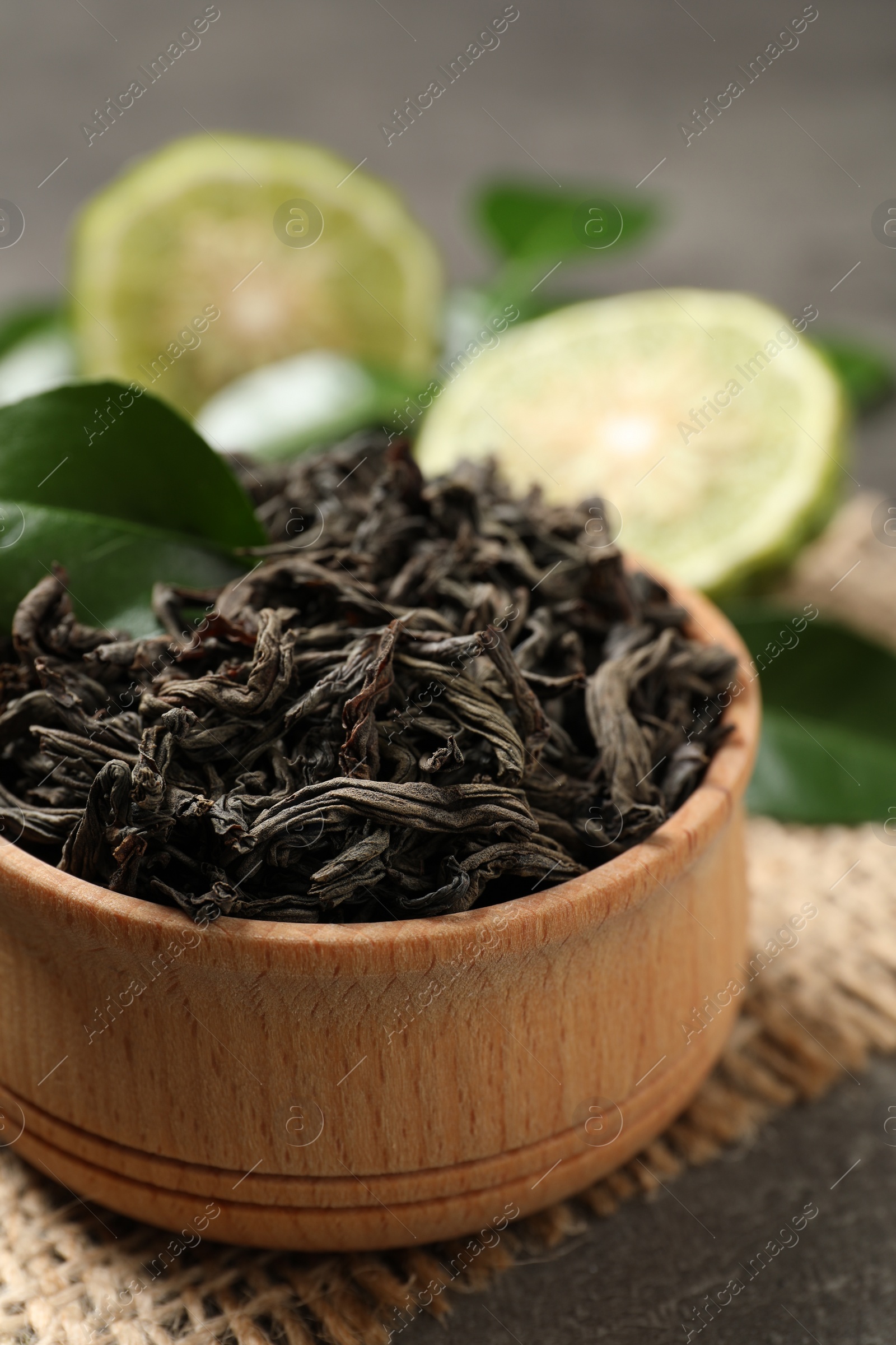 Photo of Dry bergamot tea leaves on grey table, closeup