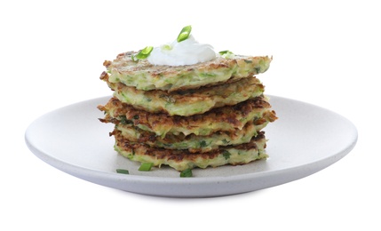 Photo of Delicious zucchini fritters with sour cream on white background