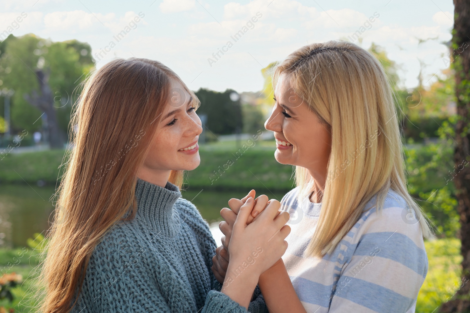 Photo of Happy mother with her daughter spending time together in park on sunny day