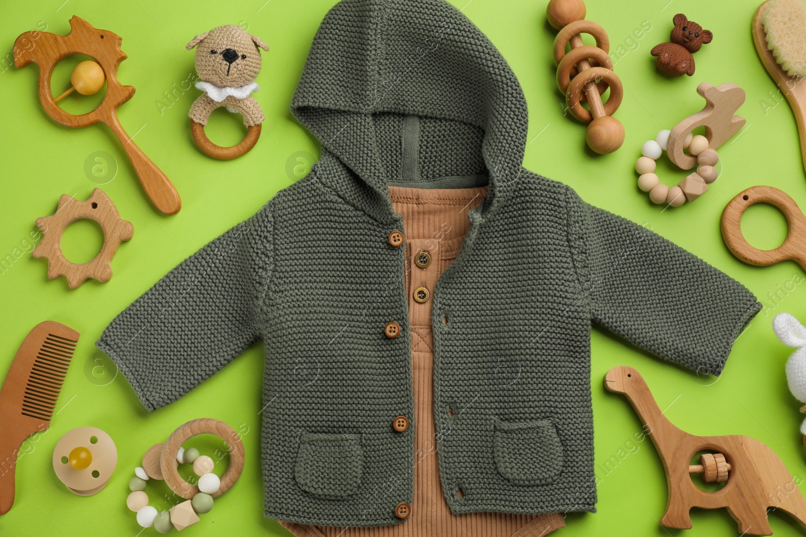 Photo of Flat lay composition with baby clothes and accessories on green background