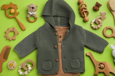 Photo of Flat lay composition with baby clothes and accessories on green background