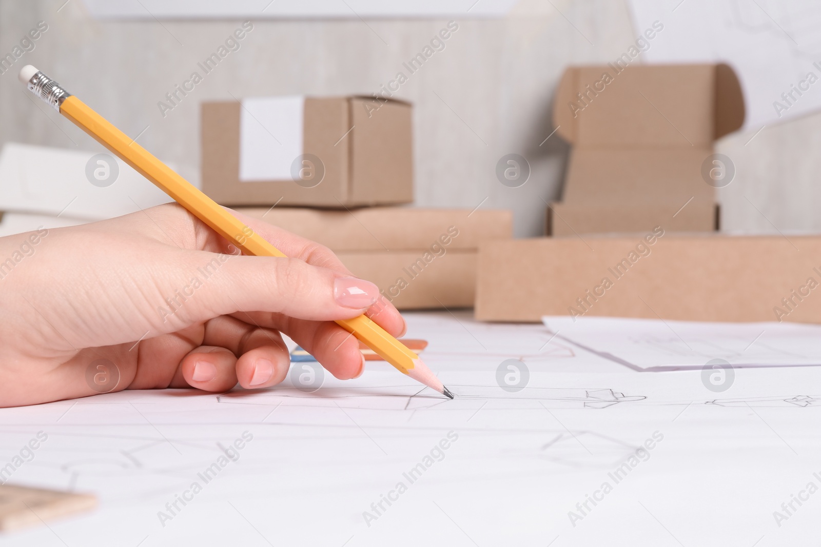 Photo of Woman creating packaging design at table, closeup