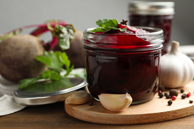 Delicious pickled beets and spices on wooden table