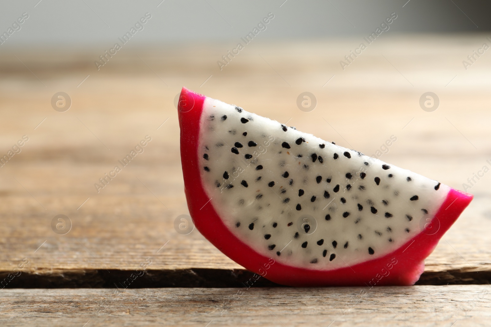 Photo of Slice of delicious ripe dragon fruit (pitahaya) on wooden table