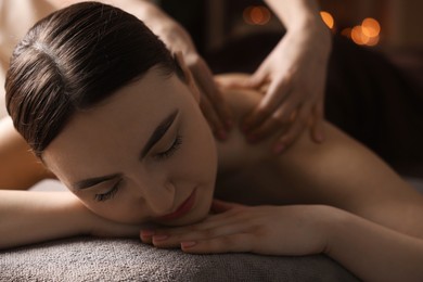 Photo of Spa therapy. Beautiful young woman lying on table during massage in salon, closeup