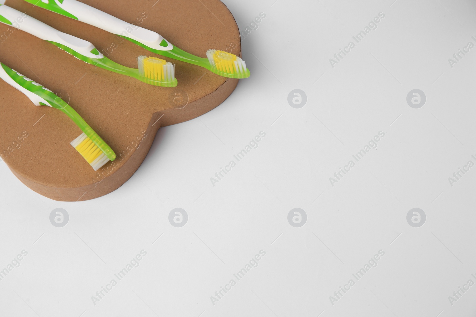 Photo of Light green toothbrushes on white background, above view. Space for text