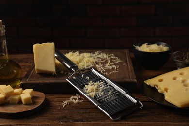 Photo of Different types of cheese and grater on wooden table
