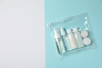 Photo of Cosmetic travel kit in plastic bag on color background, top view and space for text. Bath accessories