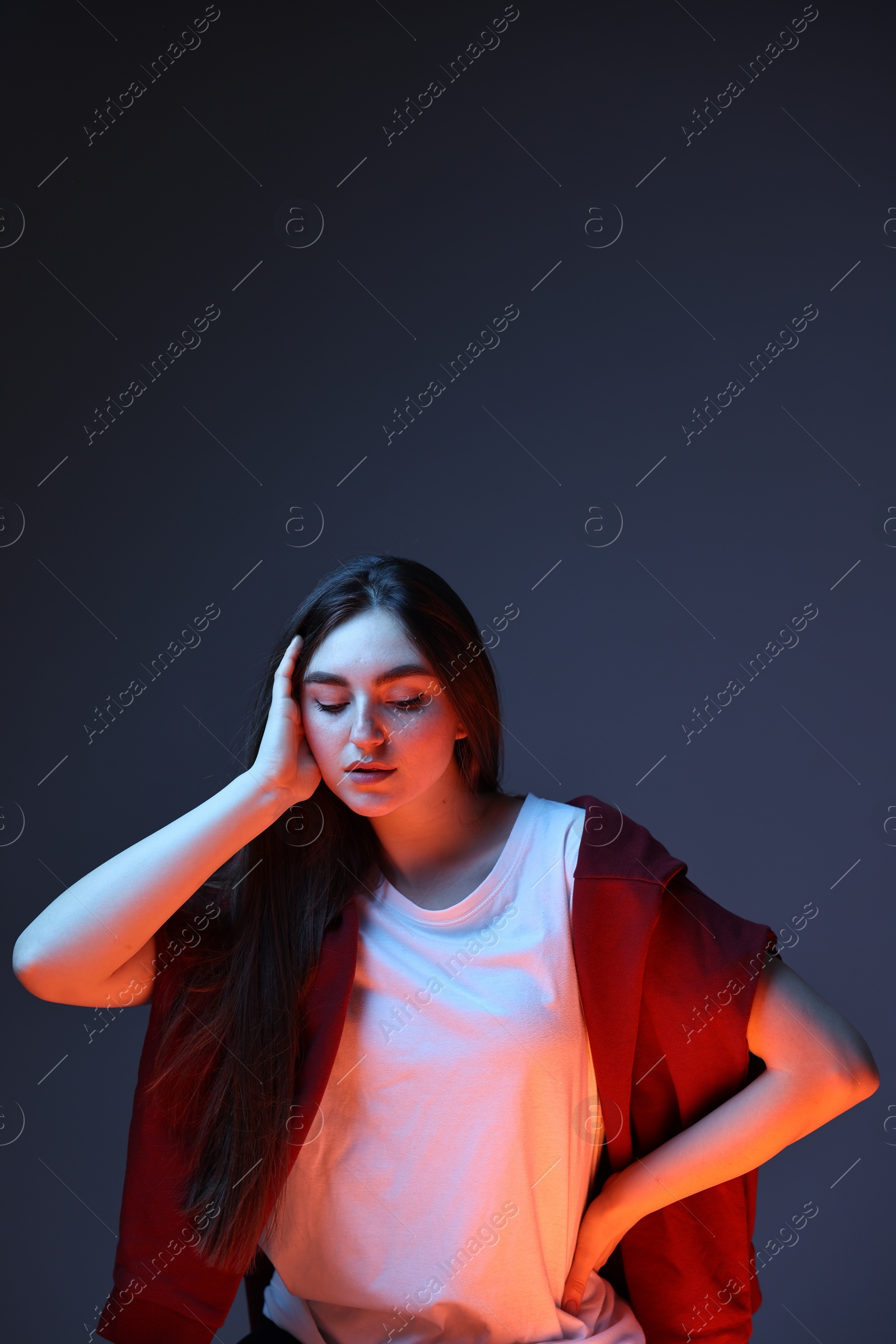 Photo of Portrait of beautiful woman on dark blue background in neon lights. Space for text