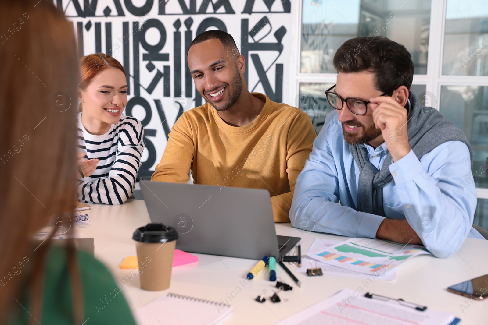 Photo of Team of employees working together at table in office. Startup project