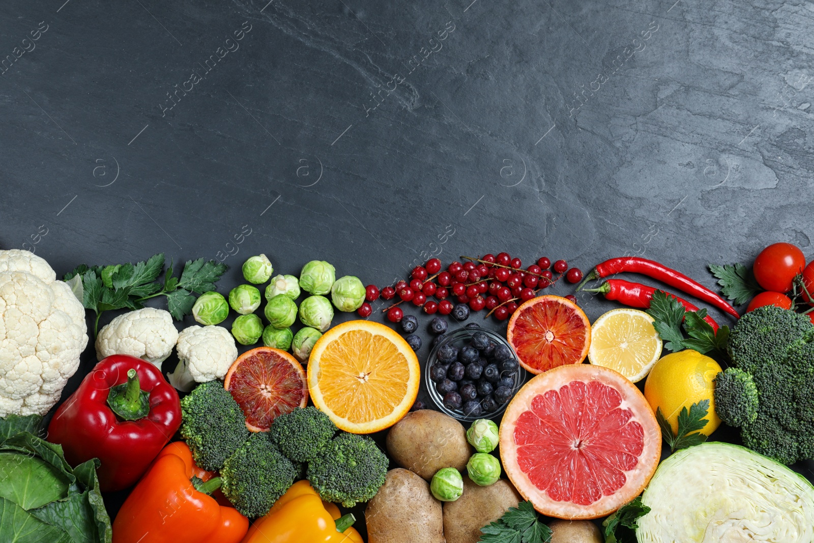 Photo of Different products rich in vitamin C on black table. Space for text