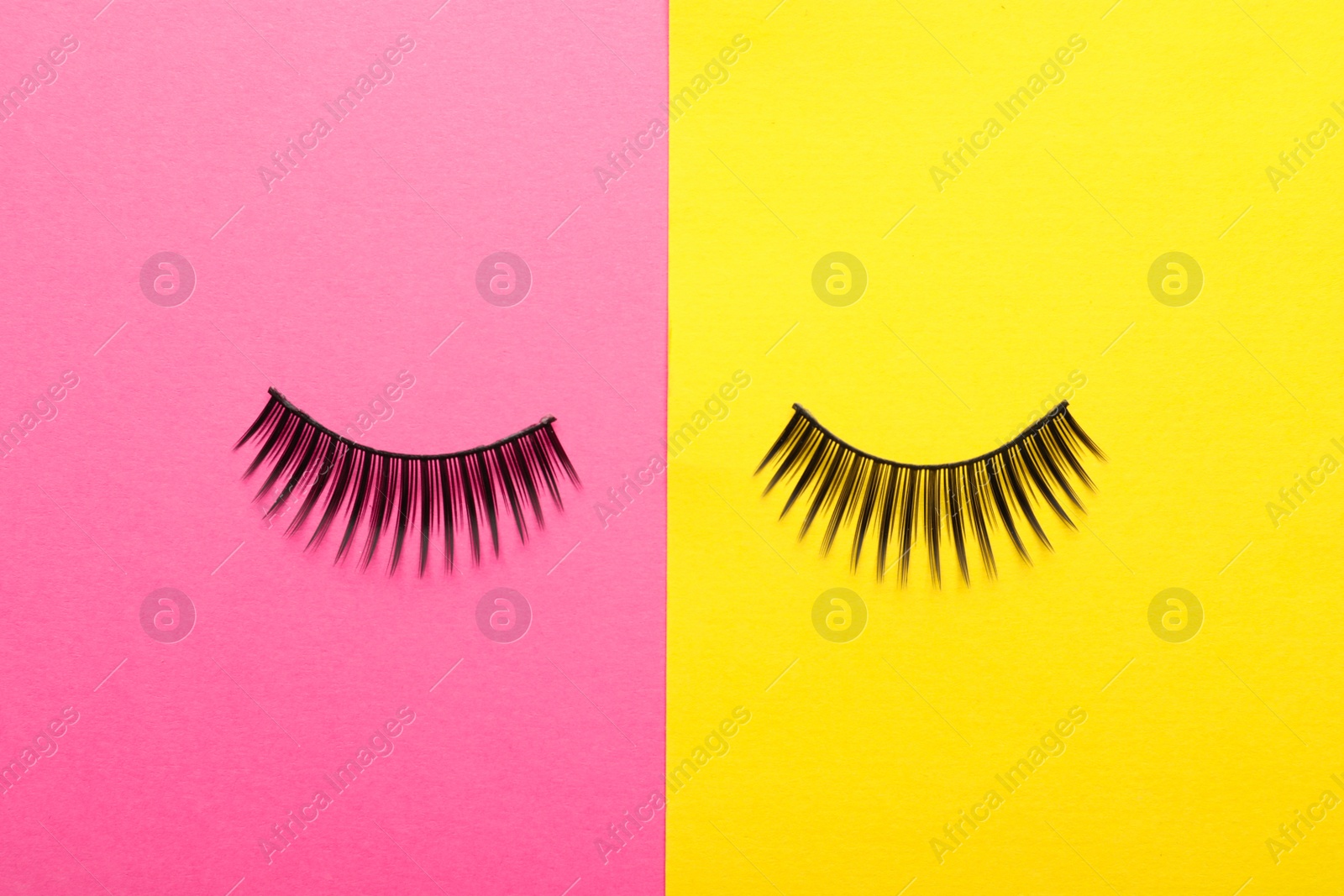 Photo of False eyelashes on color background, flat lay