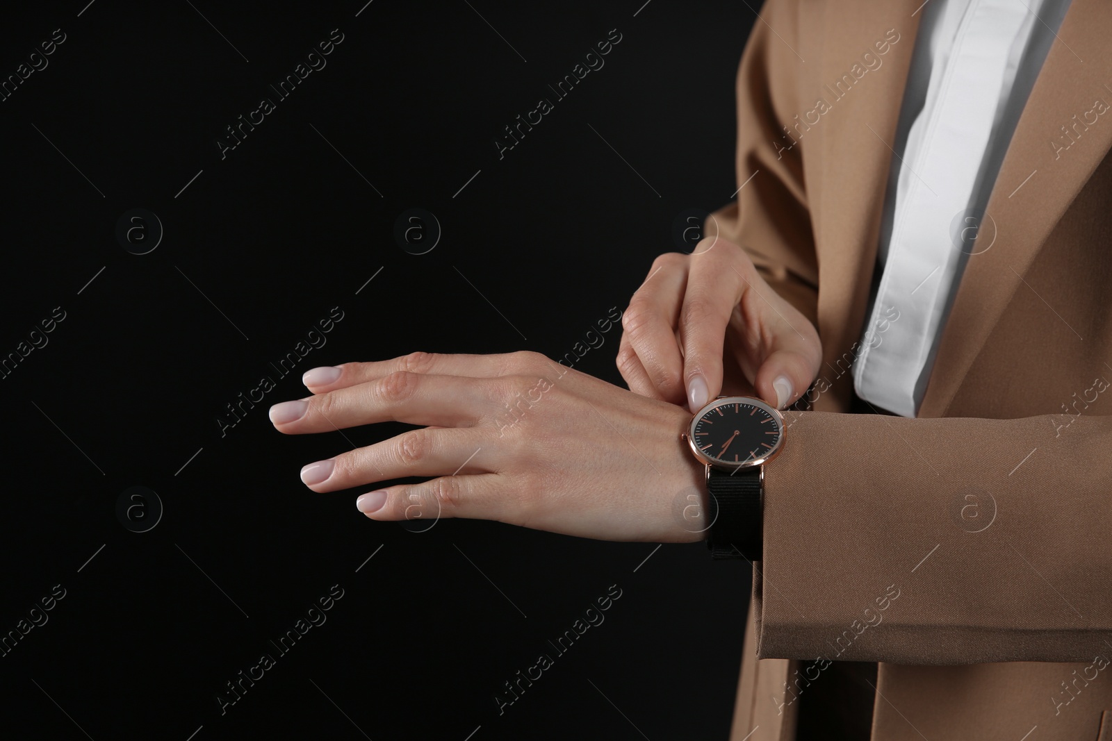 Photo of Businesswoman with wristwatch on black background, closeup. Time management