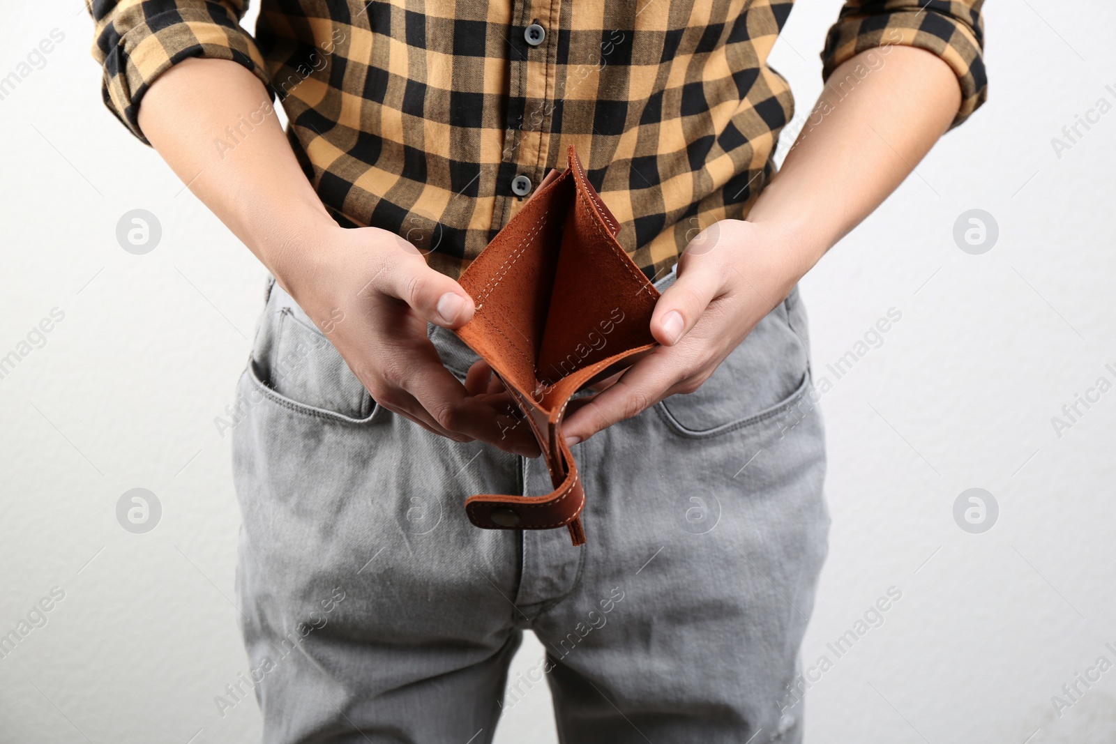 Man showing empty wallet on light background, closeup Photo of Man showing empty wallet on light background, closeup