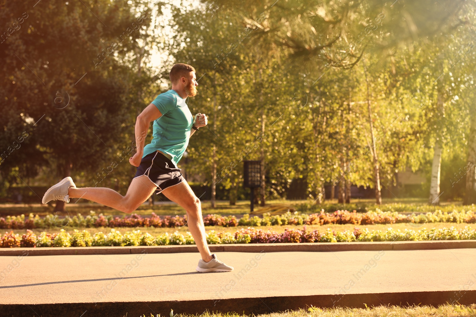 Photo of Young man running in park on sunny day