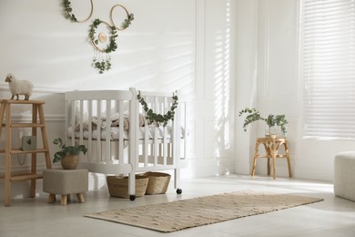 Photo of Stylish baby room decorated with eucalyptus branches