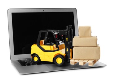 Photo of Laptop, toy forklift with wooden pallet and boxes on white background