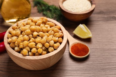 Photo of Delicious chickpeas and different products on wooden table, space for text. Hummus ingredients