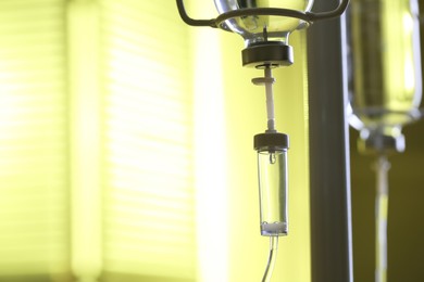 Photo of IV drip against blurred yellow background, space for text