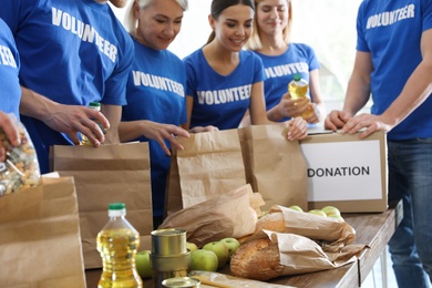 Photo of Team of volunteers collecting food donations at table, closeup