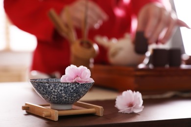 Photo of Traditional tea ceremony, focus on cup. Master near tray, closeup