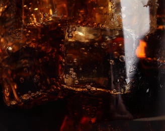 Photo of Glass of refreshing soda drink with ice cubes as background, closeup