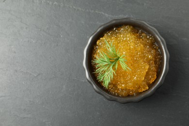 Photo of Fresh pike caviar in bowl on black table, top view. Space for text