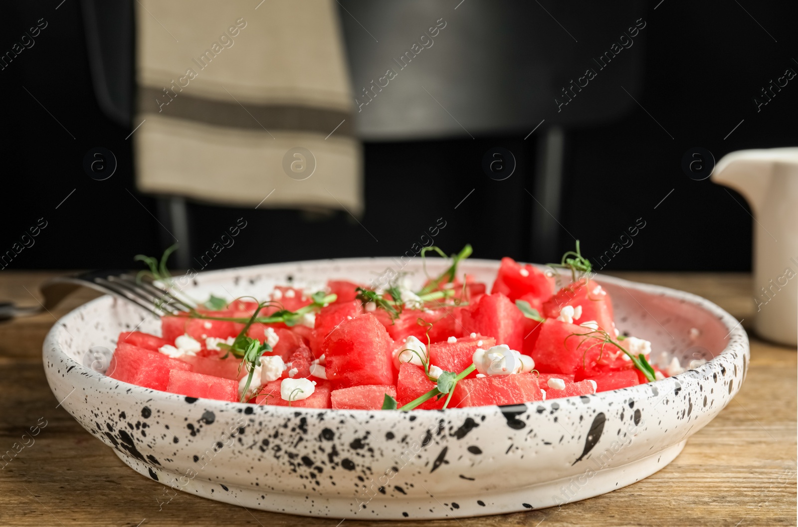 Photo of Delicious salad with watermelon served on wooden table