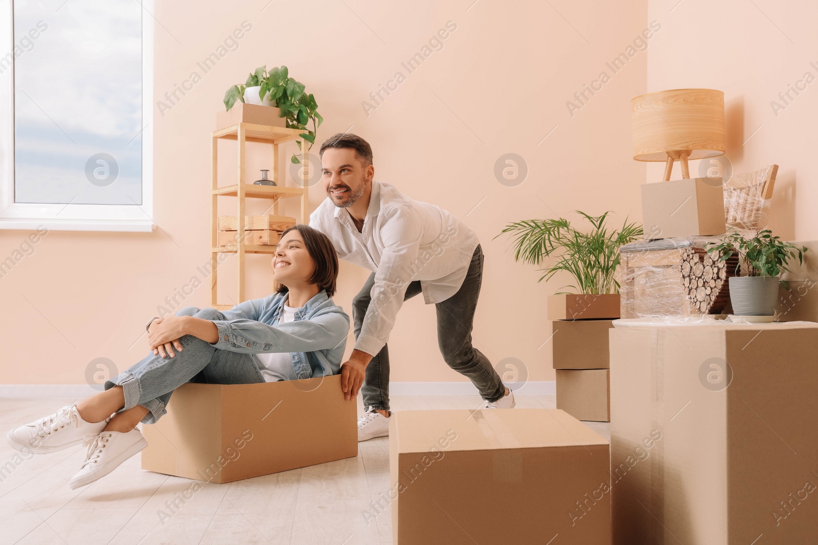 Photo of Happy couple having fun in new apartment. Moving day