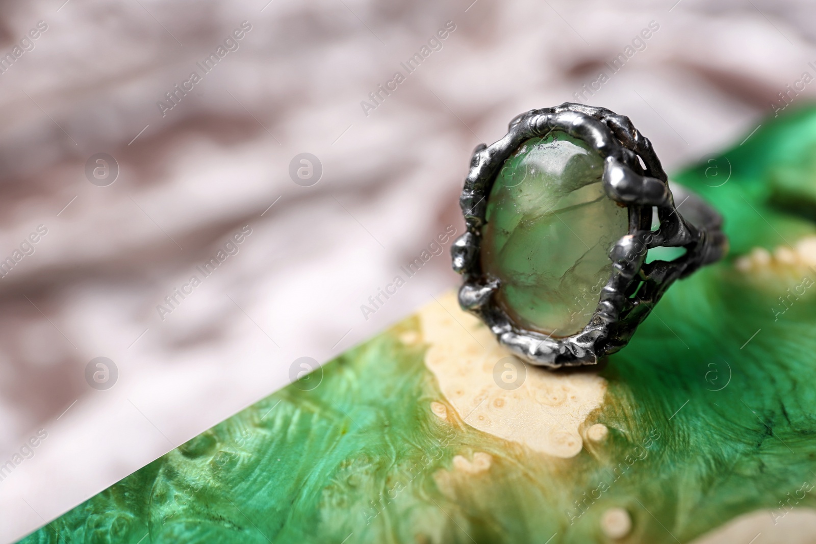 Photo of Beautiful silver ring with prehnite gemstone on textured surface. Space for text